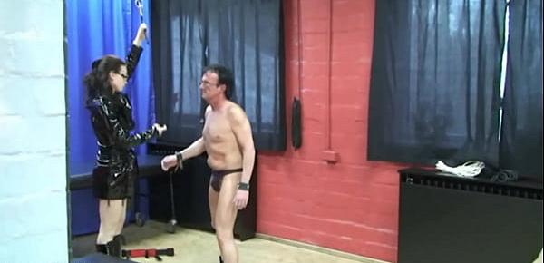 Domina erzieht zwei Sklaven schmerzhaft mit Spanking und Bondage, gefesselt sind sie ihrer sadistischen Lust ausgeliefert, sie trägt ein glänzendes Lackoutfit und geile Stiefel, zwingt die devoten Slaves auf die Knie und benutzt sie als ihr Spie